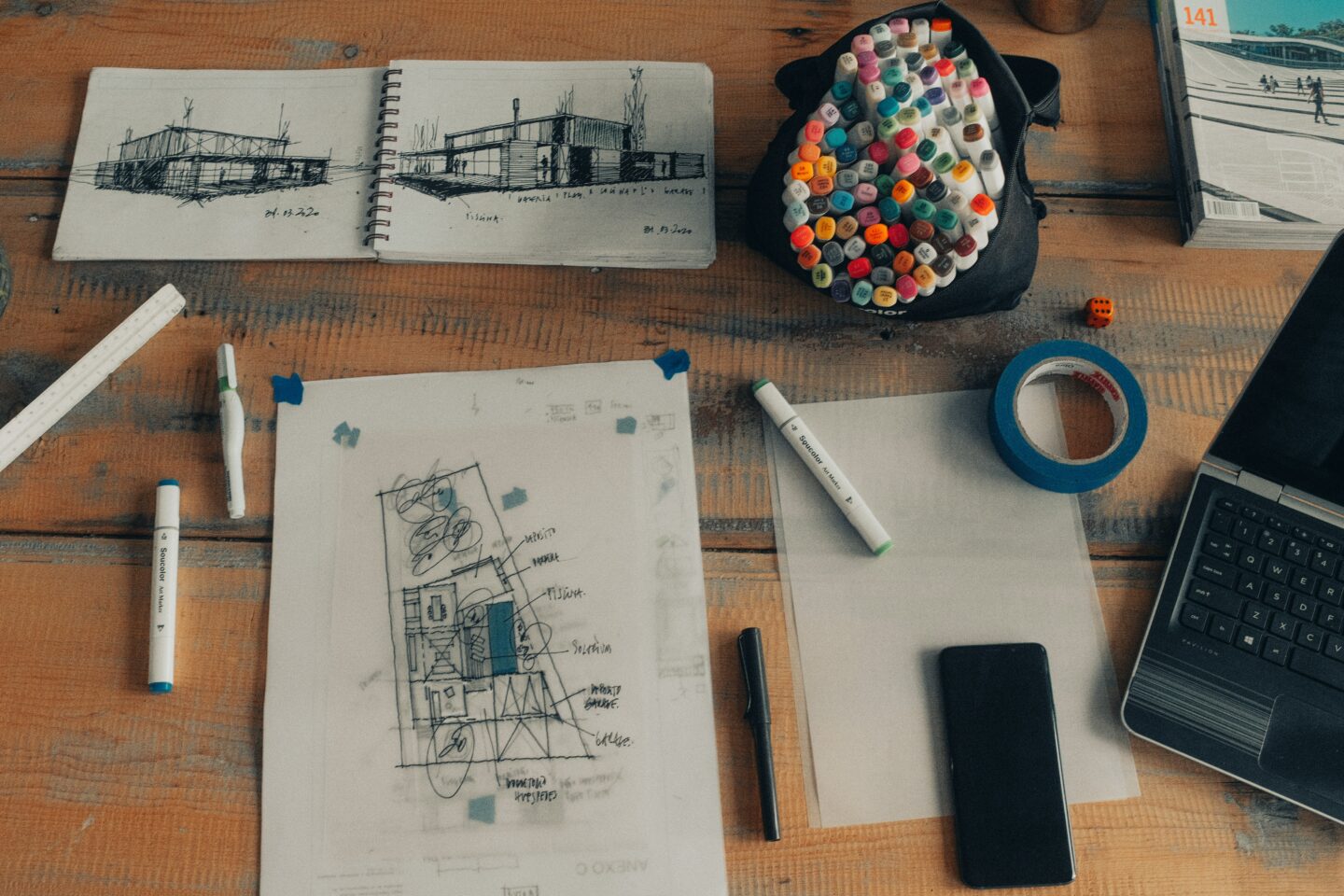 A hand drawn plan by an architect on a wooden table